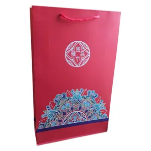 Rote Papiertragetasche für Schals, traditionelles Muster und Kordel für elegante Geschenke.