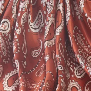 Detailed view of the vintage rust red paisley print silk-feel square scarf fabric texture.