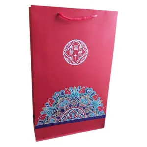 Rote Papiertragetasche für Schals, elegante Geschenkverpackung mit traditionellem Muster.