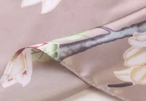 Close up detail of smooth silk satin square scarf featuring elegant floral branch print.