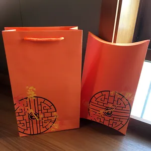 Orange gift bag and pillow box packaging set, perfect for festive holiday gifting and wrapping.