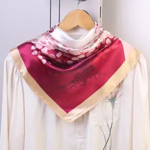 Silk square scarf detail showcasing glossy satin texture and elegant red floral tree pattern print.