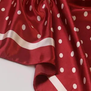 Close-up of wine red satin square scarf featuring classic white polka dots and elegant border.