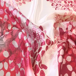 Close up detail of smooth glossy satin silk scarf with elegant red pattern design.