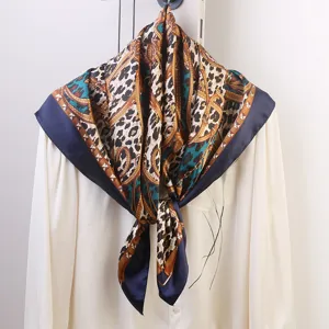 Detailed view of square silk scarf with leopard chain print and chic blue border design.