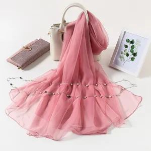 Detailed view of a solid pink ice silk chiffon scarf with delicate pearl chain decor.