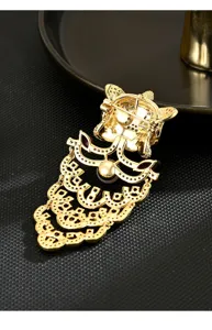 Detail shot of Chinese lion dance brooch, gold plated with red gems and rhinestones.