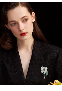 Elegant green flower brooch featuring sparkling cubic zirconia crystal details. Detail view.