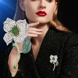 Elegant rhinestone flower brooch with green gems, perfect spring fashion accessory.