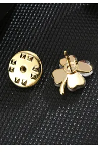 Close-up of the gold-plated four-leaf clover lapel pin and butterfly clutch backing.