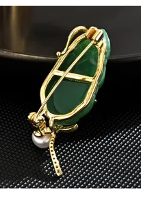 Detailed back view of the Chinese style green leaf brooch, showing pin structure and pearl.