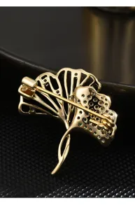 Close-up detail of the ginkgo leaf brooch back, showing secure pin and fine zircon stones.