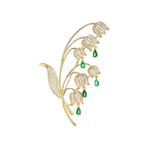 Elegante spilla a forma di mughetto con zirconi luminosi e gocce verdi per abiti ed eventi.