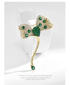 Elegant emerald leaf brooch with sparkling rhinestones and pearl accent for formal outerwear.