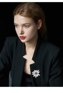 Exquisite sunflower brooch with dazzling crystals and blue center for elegant suit jacket styling.