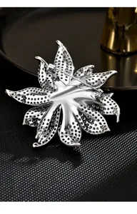 Detailed view of the exquisite silver flower brooch back pin and fine textured petal details.