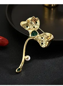 Detailed back view of elegant leaf brooch, gold-tone metal with green stones and pearl.