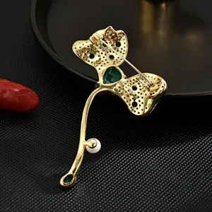 Elegant leaf brooch jewelry pin with green stone pearl details for suit coat and dress accessory.