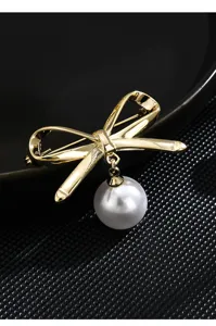 Exquisite gold-plated bow brooch featuring a dangling pearl pendant for elegant outfit styling.