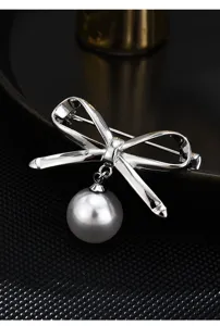 Detailed close-up view of the elegant silver bow brooch featuring a dangling white pearl.
