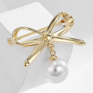 Elegant gold bow brooch with pearl pendant, perfect clothing accessory for women daily wear.