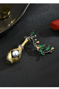 Exquisite detail shot of a vintage Chinese style vase brooch featuring a pearl and green stones.