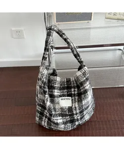 Close-up detail showing the soft texture of a black and white plaid plush tote bag