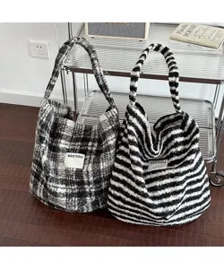 Close-up of vintage plush striped and plaid tote bags displayed in a cozy indoor setting