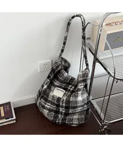 Close-up detail of a retro black and white plaid plush tote bag in a cozy home setting