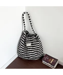 Retro black and white striped plush tote bag leaning against a wall
