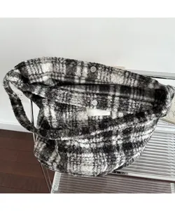 Close-up detail showing the plush plaid texture and magnetic clasp of the tote bag.