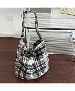 Vintage plaid plush shoulder tote bag with a white patch in a cozy home setting