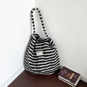 Retro black and white striped plush shoulder tote bag displayed in a cozy room corner
