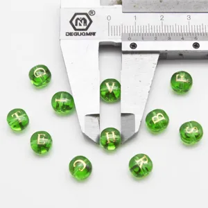 Green glass letter beads detail view, gold foil alphabet charms for DIY jewelry making accessories.