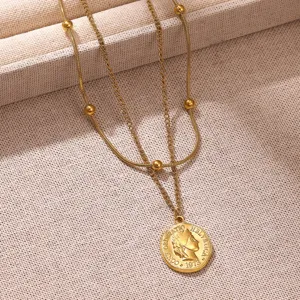 Vue détaillée d'un collier double épaisseur en or avec pendentif pièce de monnaie