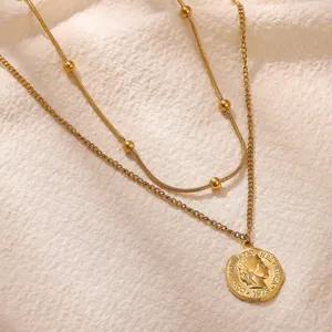 Gros plan d'un collier double rang en or avec un pendentif pièce de monnaie vintage