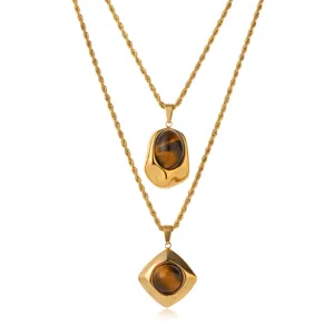 Nahaufnahme der zweilagigen goldenen Edelstahlkette mit geometrischen Naturstein Anhängern.