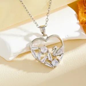 Close-up detail of the silver heart pendant necklace with sparkling zirconia and swan motif.