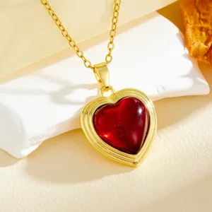 Gold-plated heart pendant necklace with red gemstone, stylish minimalist design.