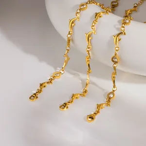 Bracciale catena con delfini in acciaio dorato e cristalli scintillanti nel dettaglio