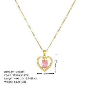 Close-up detail of the gold heart pendant necklace featuring a pink stone and crystal frame.
