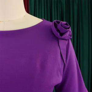 Dettaglio di un elegante abito viola che mostra la rosa di stoffa fatta a mano sulla spalla