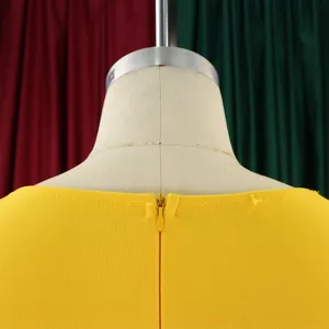 Vista dettagliata della cerniera posteriore di un abito giallo su un manichino