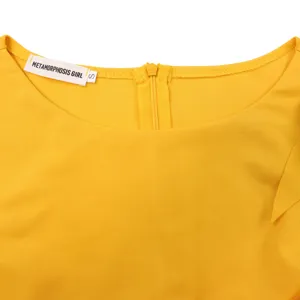 Dettaglio dello scollo dell'abito giallo con cerniera ed etichetta Metamorphosis Girl.