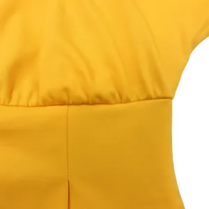Dettaglio macro della vita arricciata e delle cuciture fini su un vestito giallo