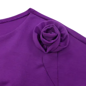 Primo piano di una rosa decorativa in tessuto su un abito africano viola a maniche corte