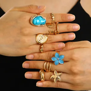 Primo piano di anelli d'oro vintage con perla barocca blu e forme di stella marina