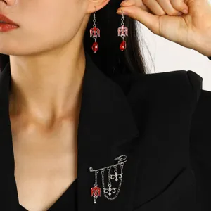 Close-up of a model wearing Kazakh-style brooch and red teardrop earrings with a black blazer