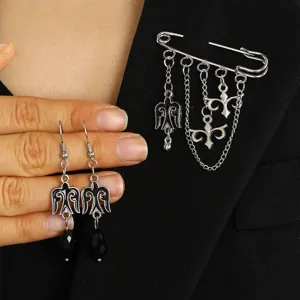 Close-up of ethnic style silver brooch with chains and matching dangle earrings
