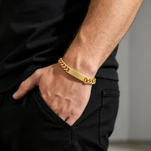 Close-up van een gouden cuban link herenarmband met een graveerbare ID-plaat.